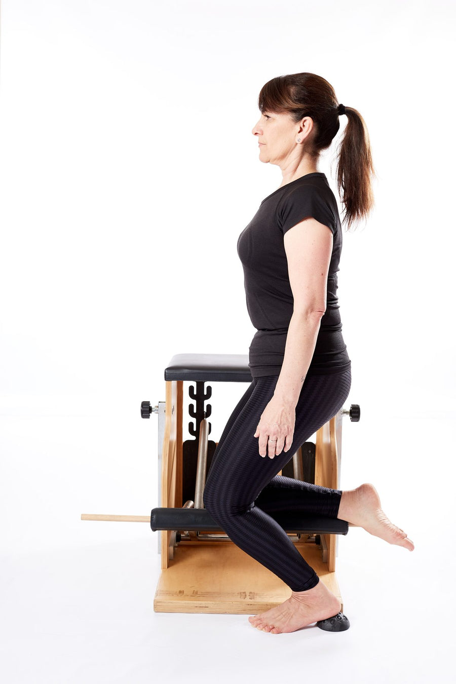 Femme en fente latérale au Wunda Chair, le pied posé sur un dôme Lotus moyen
