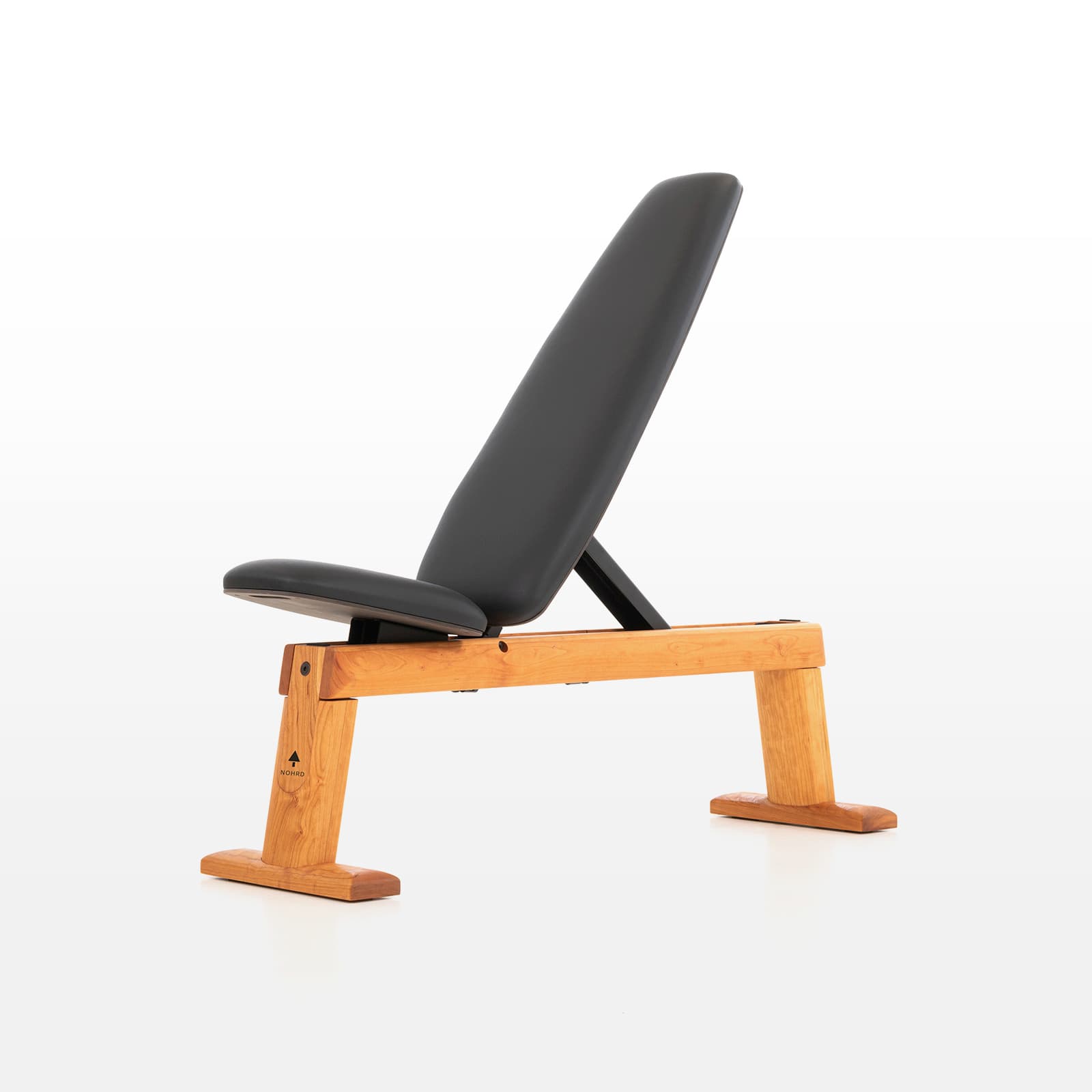 #Variante_Kirsche Eine freigestellte NOHRD WeightBench Hantelbank aus Kirschholz mit schwarzer Kunstlederpolsterung in schräger Position.