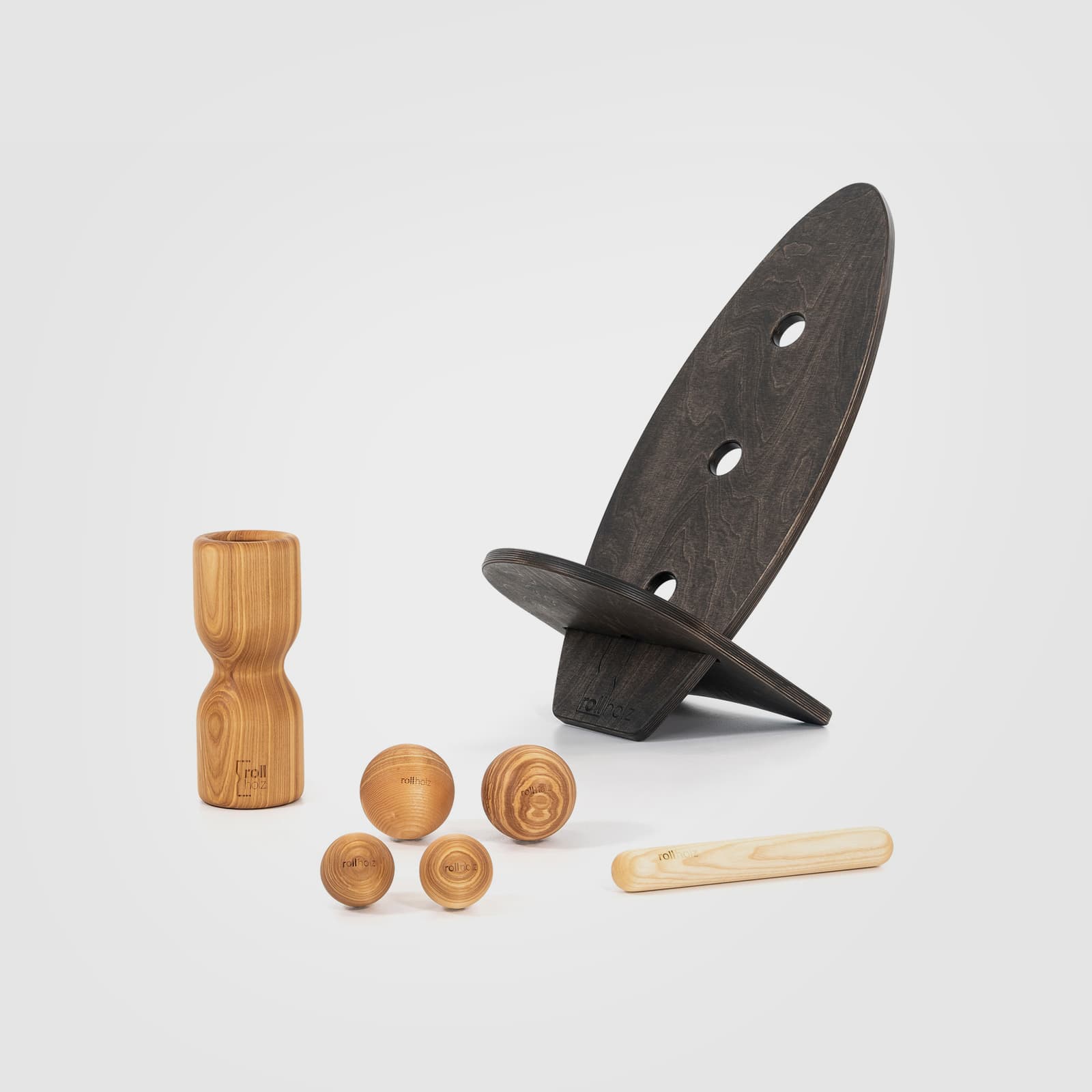 #Variante_Esche schwarz rollholz Balanceboard Set Groß 2.0: Zwei schwarz geölte Boards, die ineinandergesteckt einen Sitz ergeben, geliefert mit Faszienrolle, vier Kugeln und Minibar aus edlem Eschenholz.