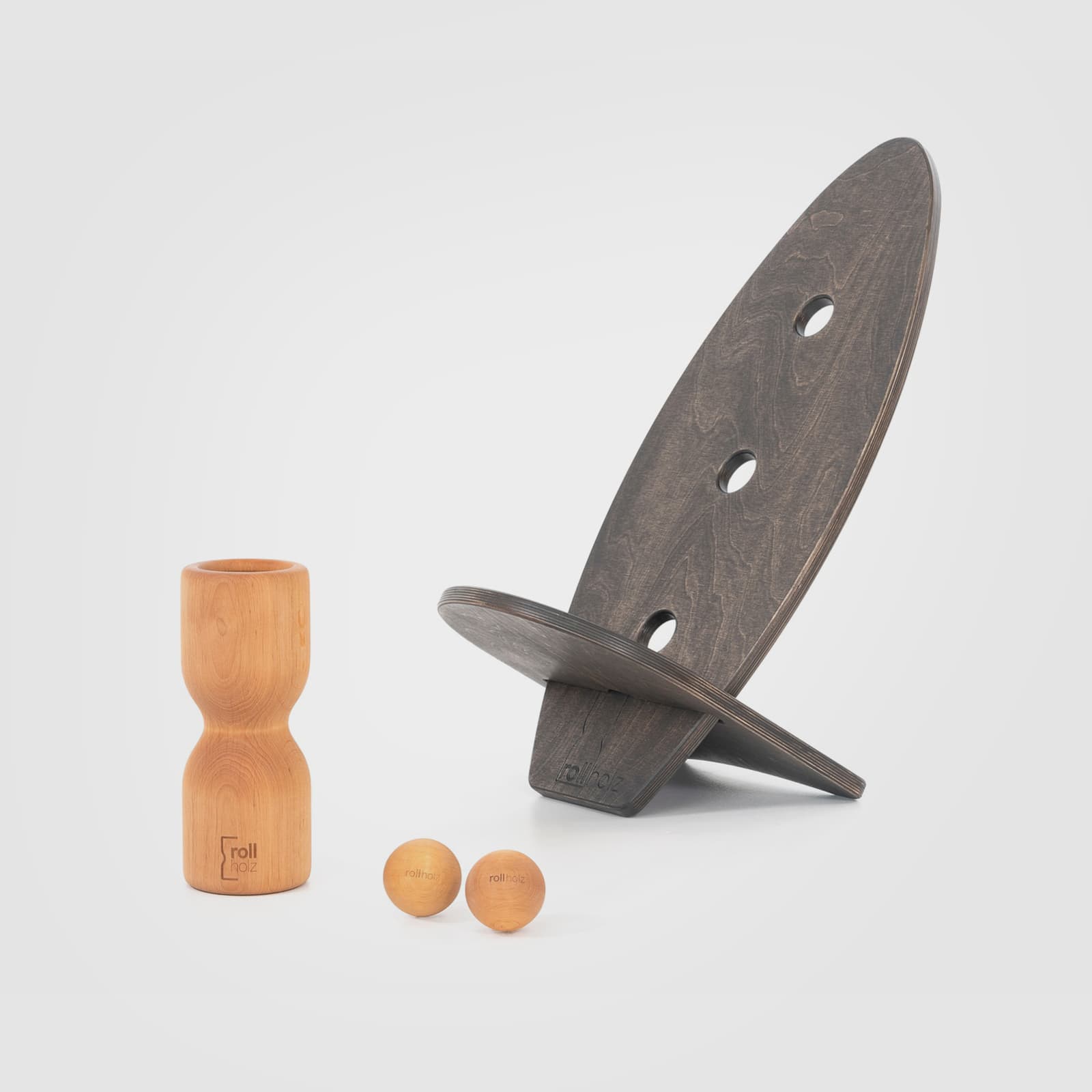 #Variante_Erle schwarz rollholz Balanceboard Set Klein 2.0: Zwei kleine, schwarz geölte Multiplex-Boards im cleveren Steck-Sitz-Design, kombiniert mit einer Faszienrolle und zwei großen Massagekugeln aus warmem Erlenholz.