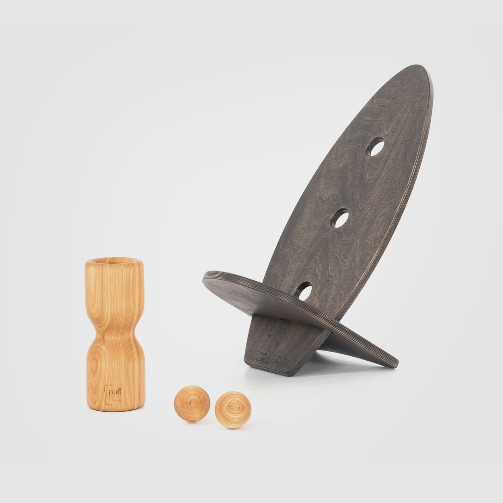 #Variante_Esche schwarz rollholz Balanceboard Set Klein 2.0: Zwei schwarz geölte, kleine Boards, die ineinandergesteckt einen Hocker ergeben, geliefert mit einer Faszienrolle und zwei Massagekugeln aus ausdrucksstarkem Eschenholz.
