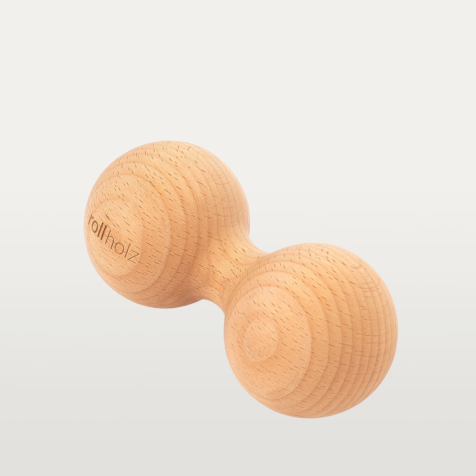#Holz_Buche Freigestellte Ansicht einer 7 cm rollholz Doppelkugel aus klassischem Buchenholz mit präzise eingelasertem Markenlogo.