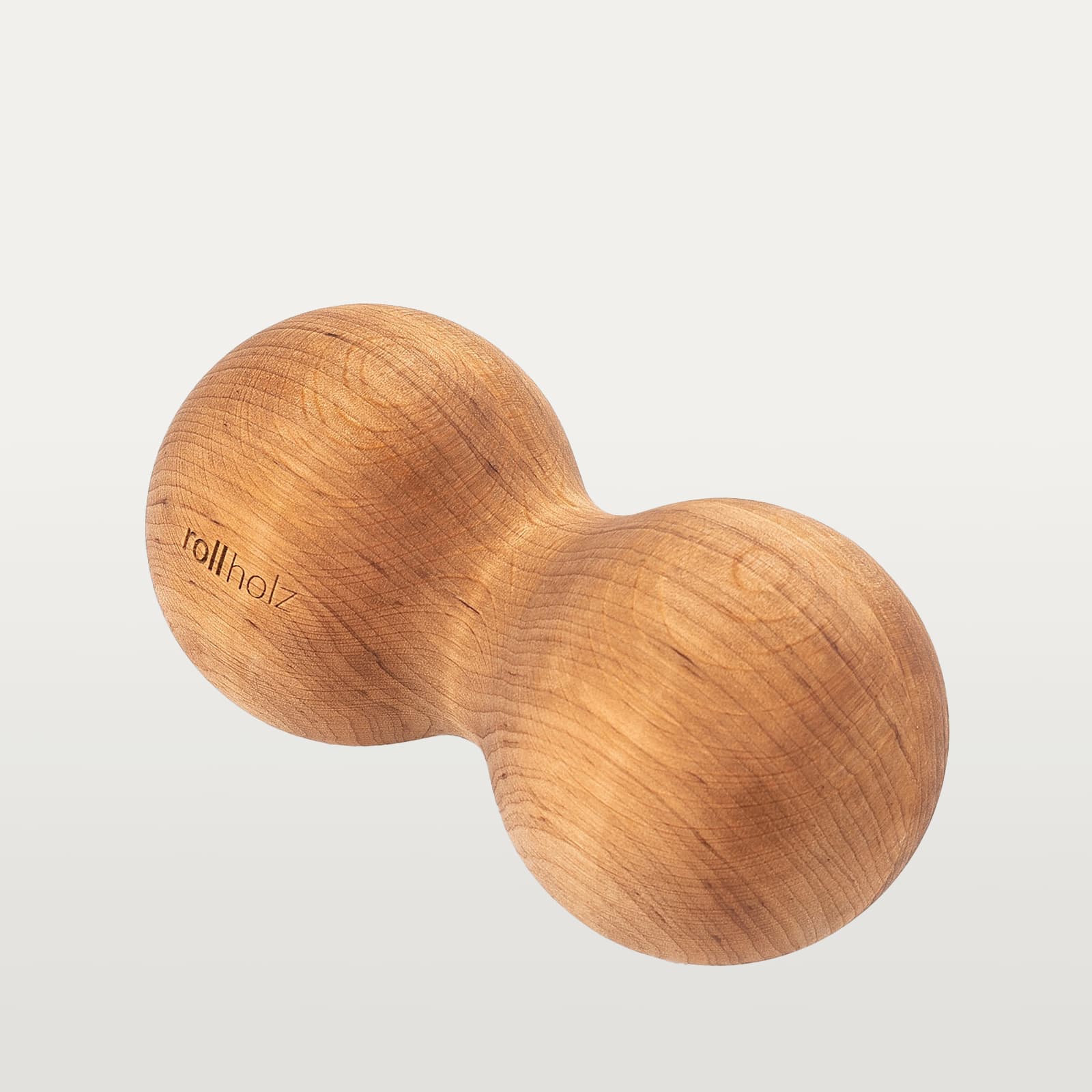 #Holz_Erle Freigestellte Ansicht einer rollholz Doppelkugel XL aus rötlich-warmem Erlenholz mit präzise eingelasertem Markenlogo.