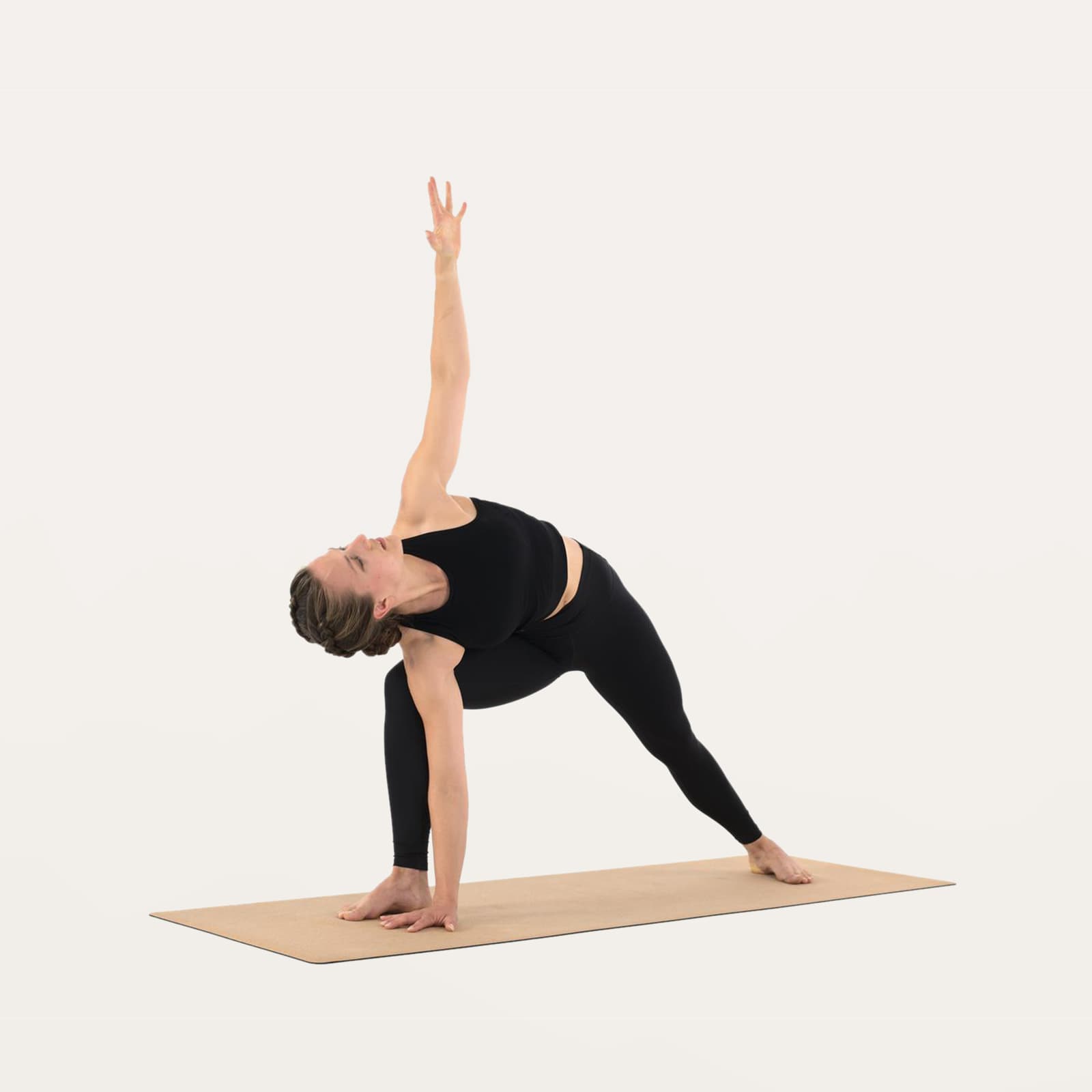 Eine Frau praktiziert eine Yoga-Übung (gedrehtes Dreieck) auf einer freigestellten rollholz Kork-Yogamatte aus Naturkork und Kautschuk.
