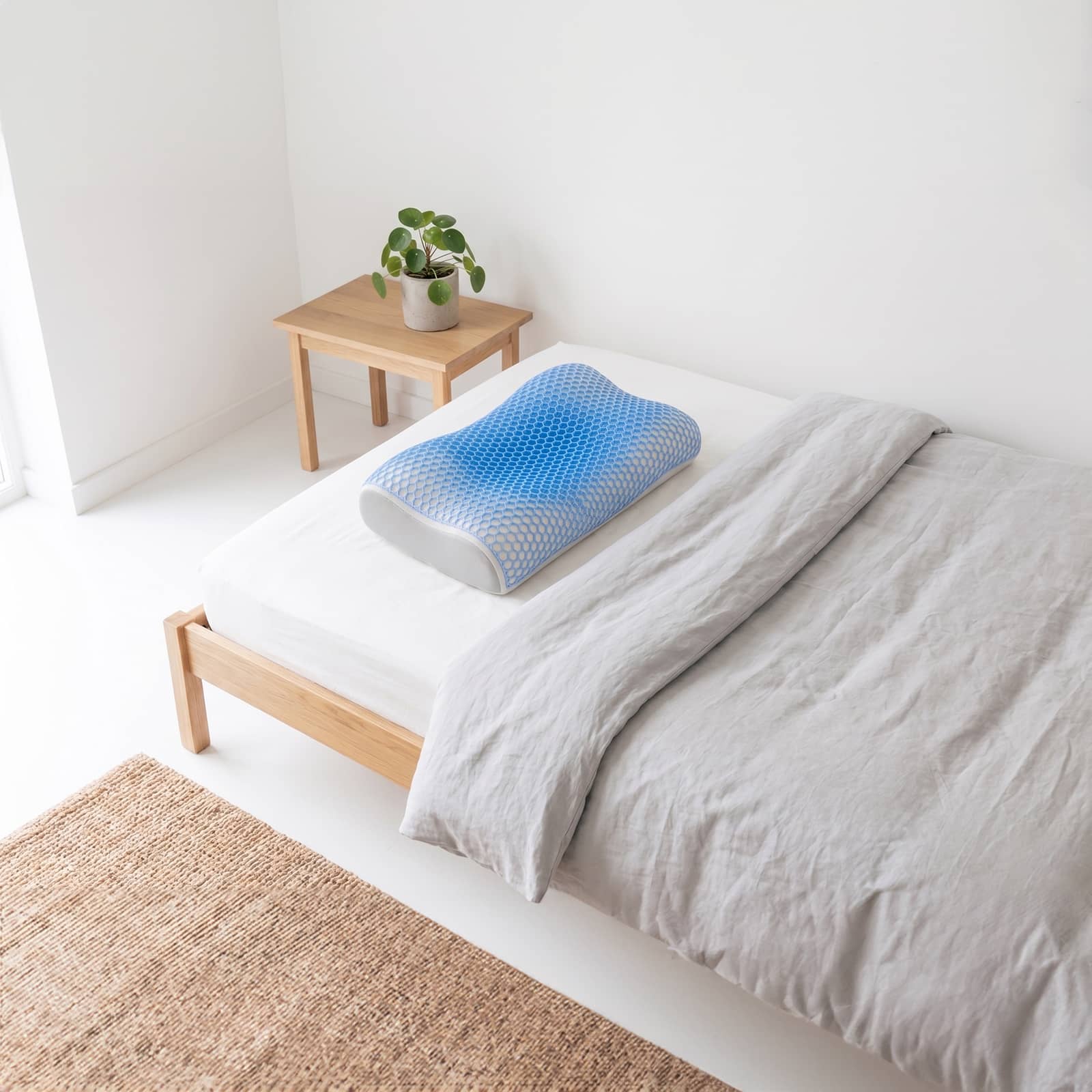 Ergonomisches, extra großes Schlafkissen mit kühlender 3D-Struktur liegt auf einem Bett.