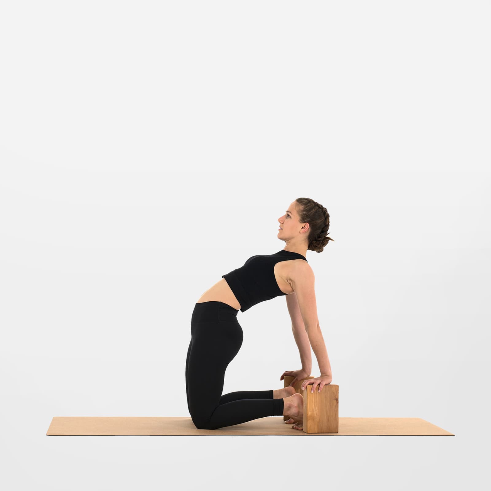 Frau praktiziert eine Yoga-Übung mit zwei Blöcken aus Erlenholz auf einer rollholz Korkmatte.
