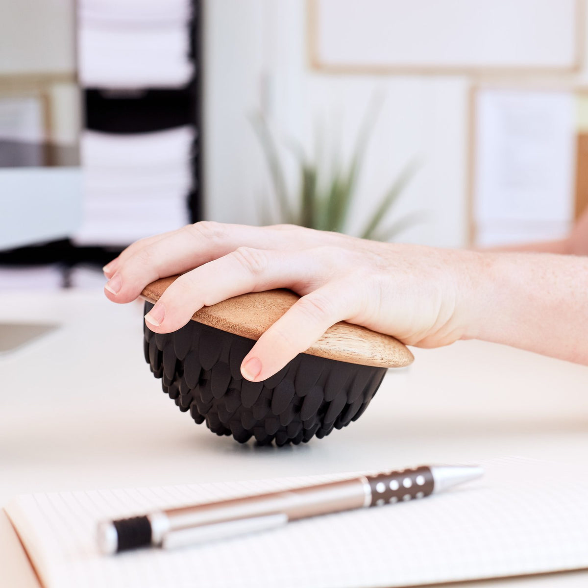 Main posée sur un dôme Lotus avec base en bois au bureau pour mobiliser le poignet et l'avant-bras