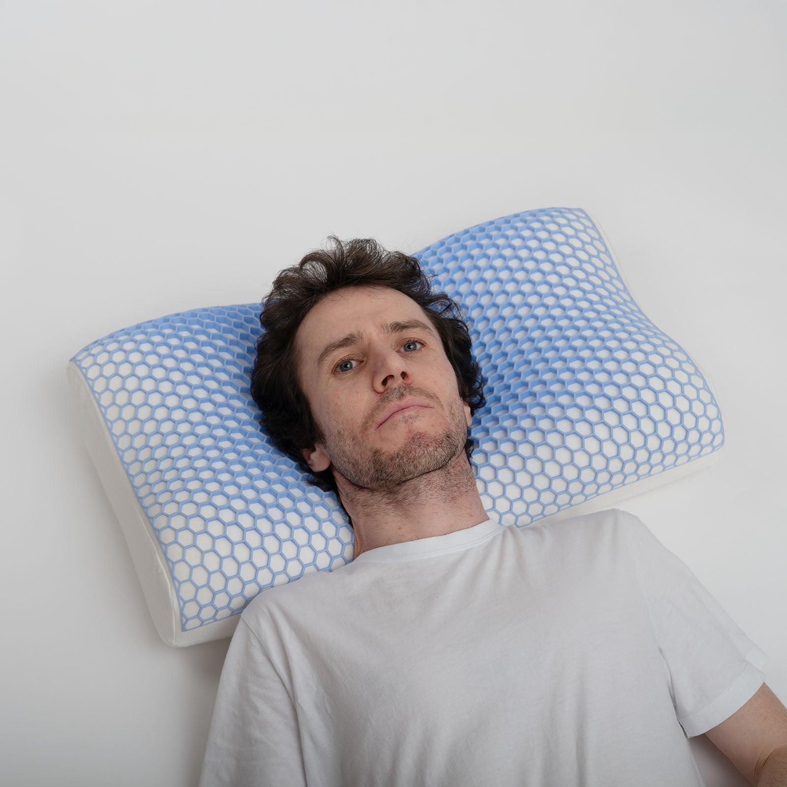 Junger Mann liegt auf Kissen in Studioumgebung