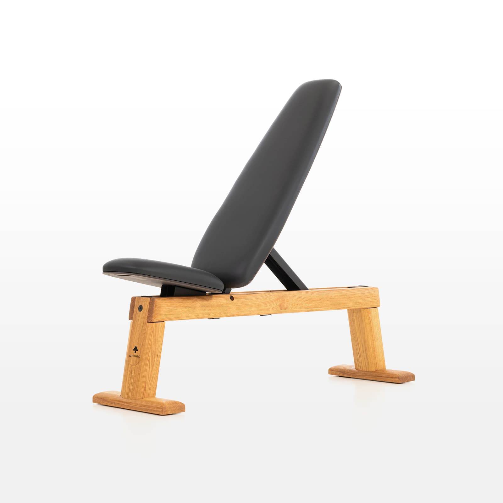 #Variante_Eiche  Eine freigestellte NOHRD WeightBench Hantelbank aus Eichenholz mit schwarzer Kunstlederpolsterung in schräger Position.