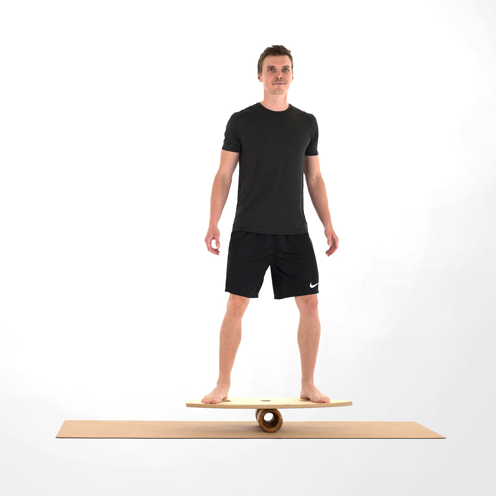 Ein Mann in schwarzer Sportkleidung trainiert barfuß im aufrechten, frontalen Stand auf einem großen rollholz Balanceboard, das mittig auf einer Holz-Faszienrolle gelagert ist.