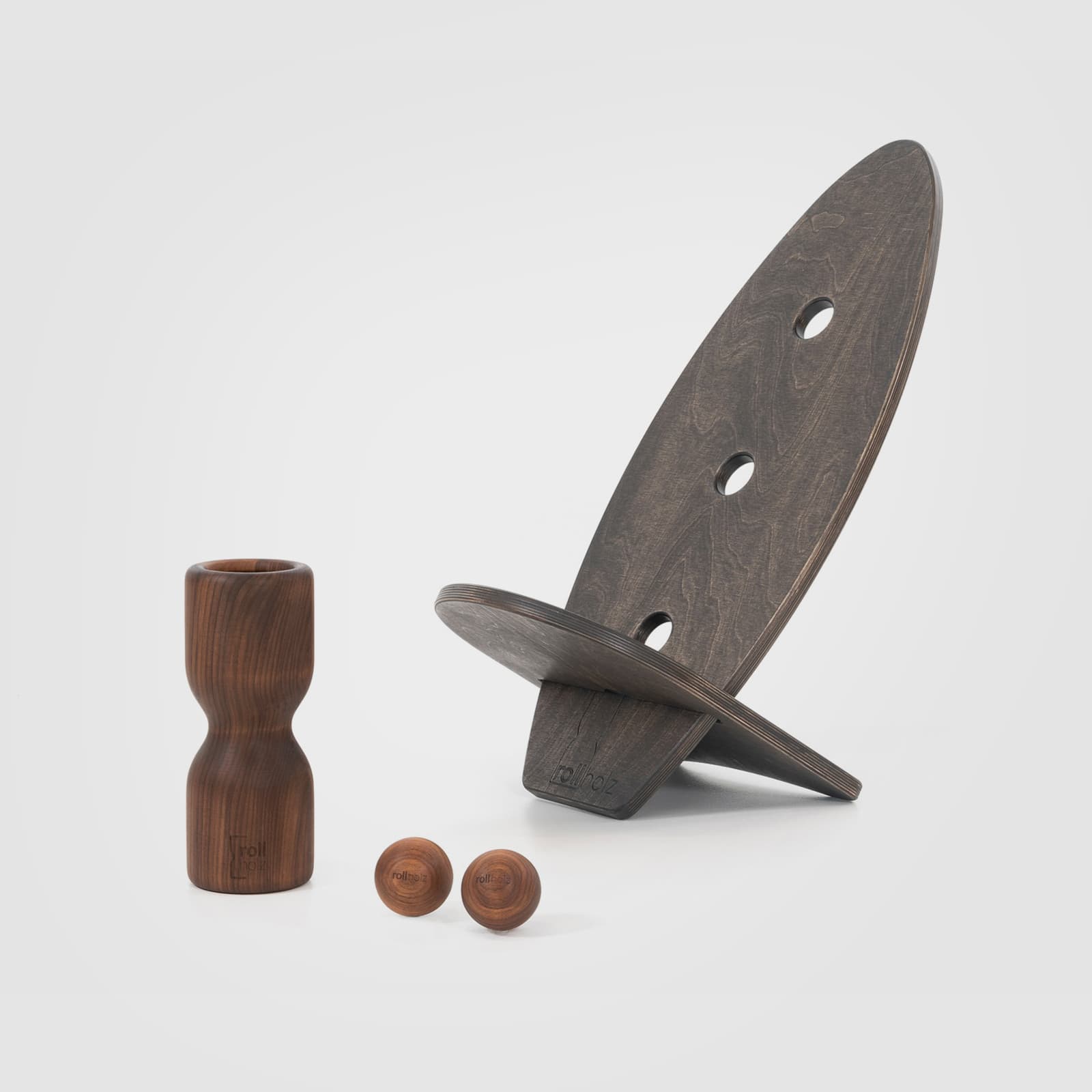 #Variante_Walnuss schwarz rollholz Balanceboard Set Klein 2.0 auf weißem Hintergrund: Zwei unabhängig nutzbare, schwarz geölte Boards zusammengesteckt als minimalistischer Design-Sitz, mit einer Faszienrolle und zwei großen Massagekugeln aus edlem Walnussholz.