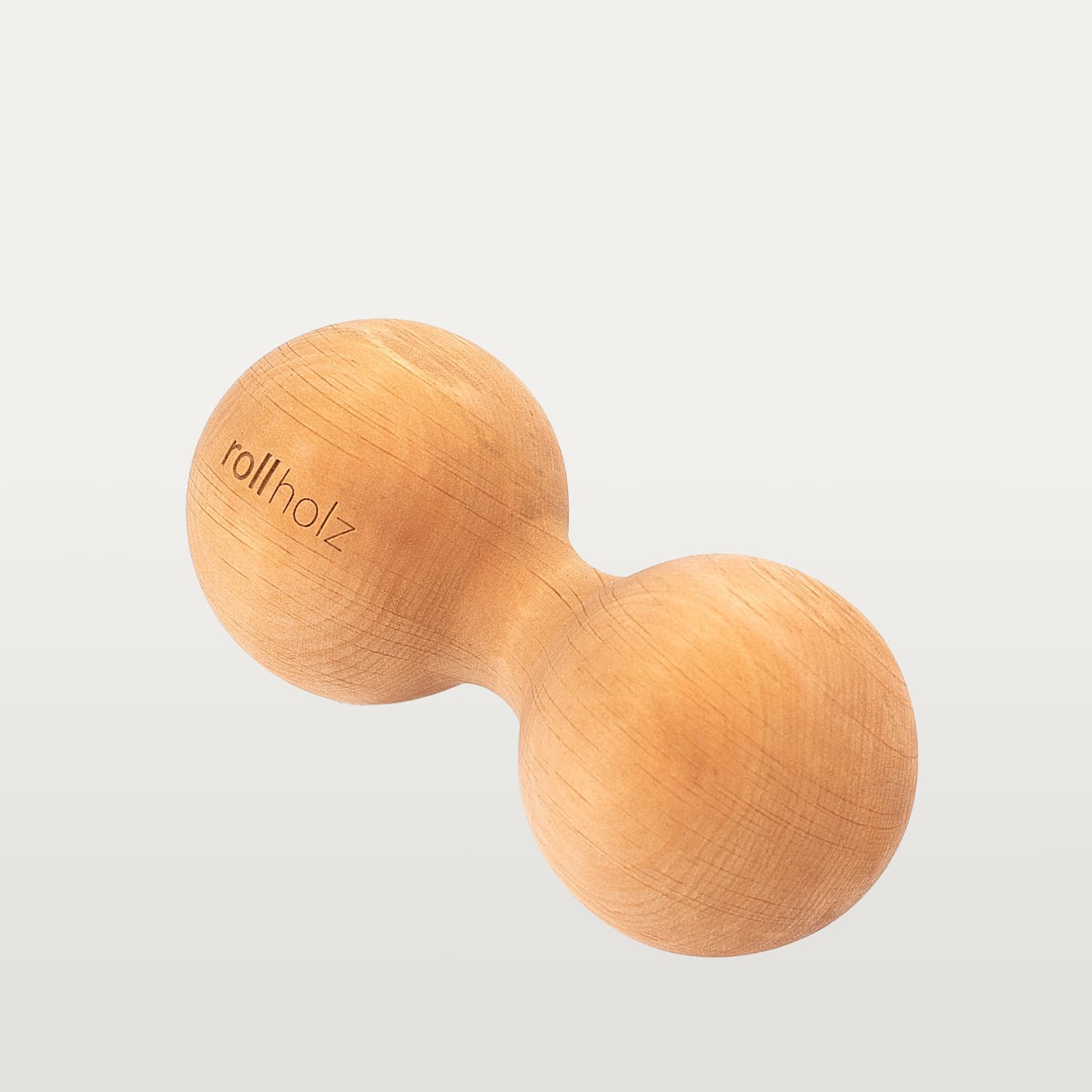 #Holz_Erle Freigestellte Ansicht einer 7 cm rollholz Doppelkugel aus rötlich-warmem Erlenholz mit präzise eingelasertem Markenlogo.