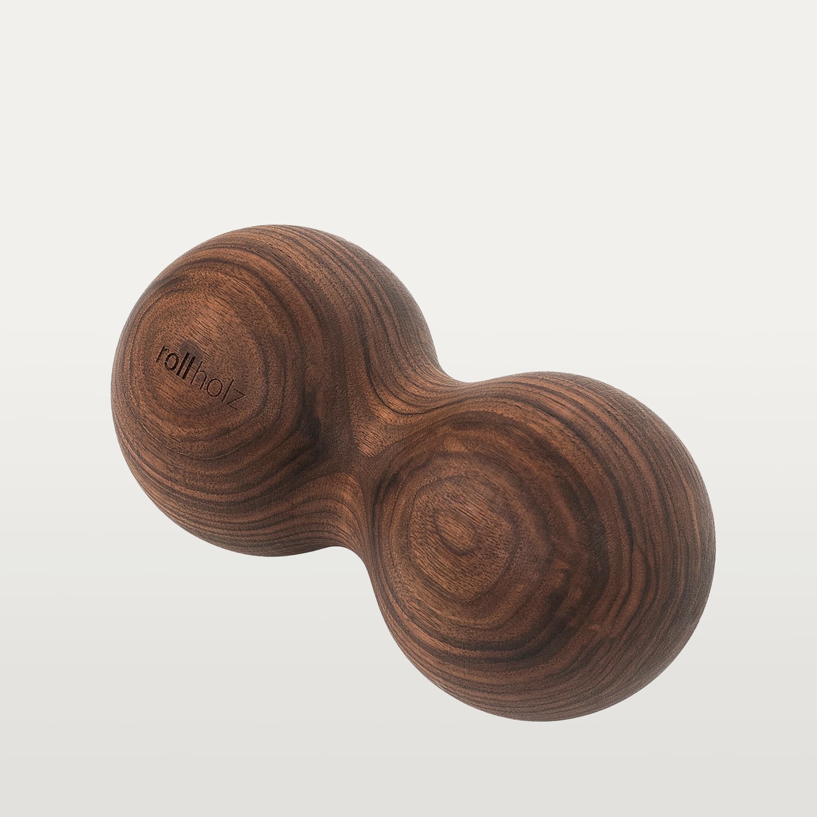 #Holz_Walnuss Freigestellte Ansicht einer rollholz Doppelkugel XL aus edlem, dunklem Walnussholz mit präzise eingelasertem Markenlogo.
