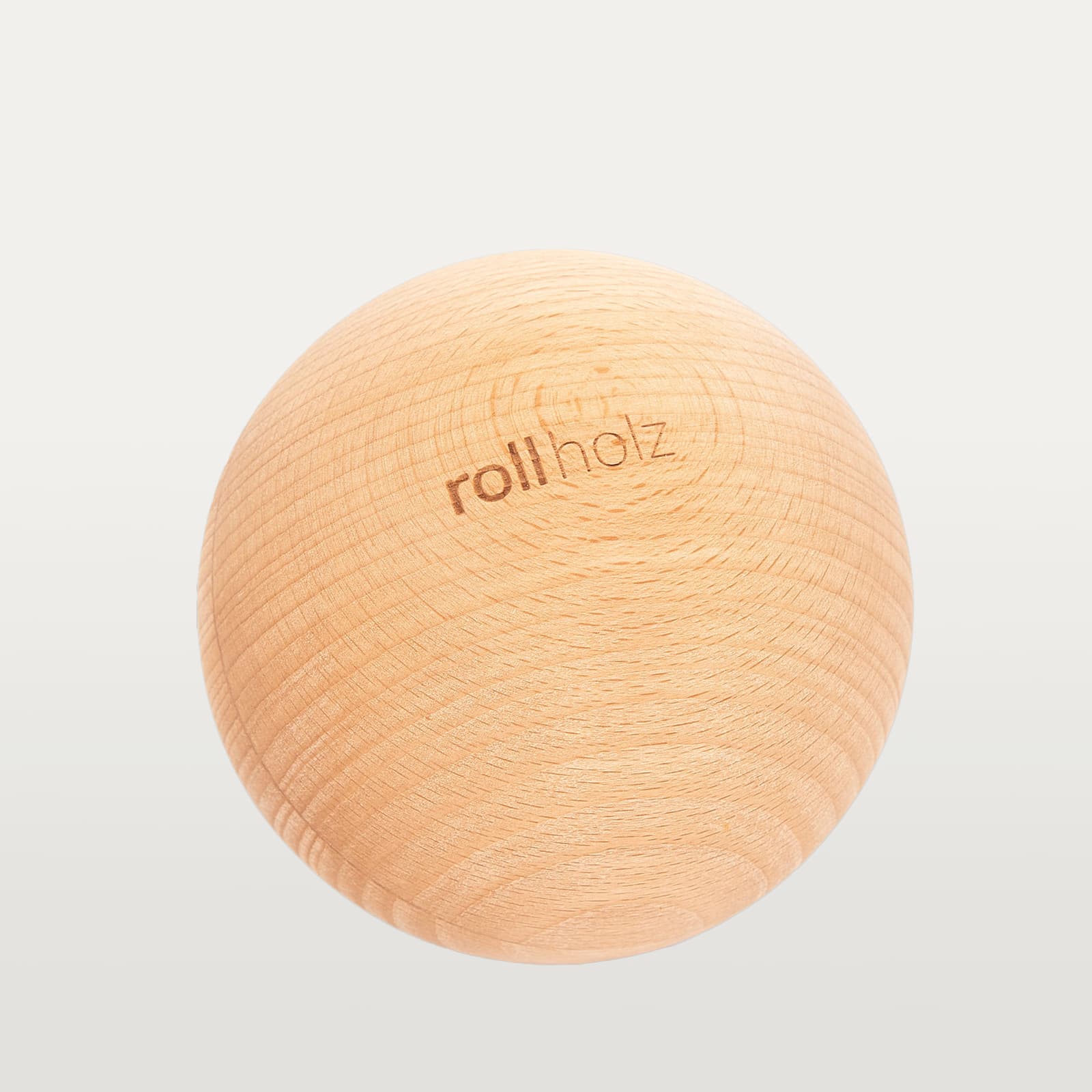 #Holz_Buche Freigestellte Ansicht einer 10 cm rollholz Faszienkugel aus klassischem Buchenholz mit detailgetreu eingelasertem Markenlogo.