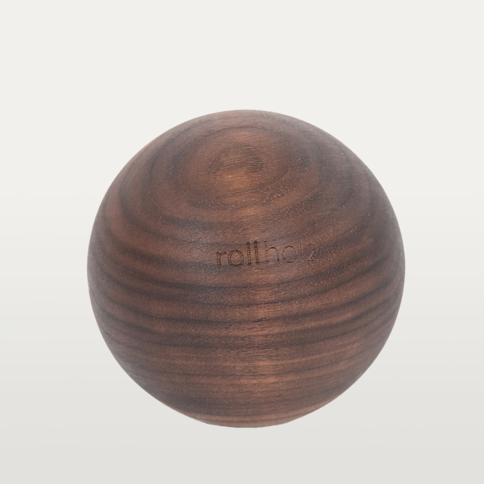 #Holz_Walnuss Freigestellte Ansicht einer 10 cm rollholz Faszienkugel aus edlem, dunklem Walnussholz mit edel eingelasertem Markenlogo.