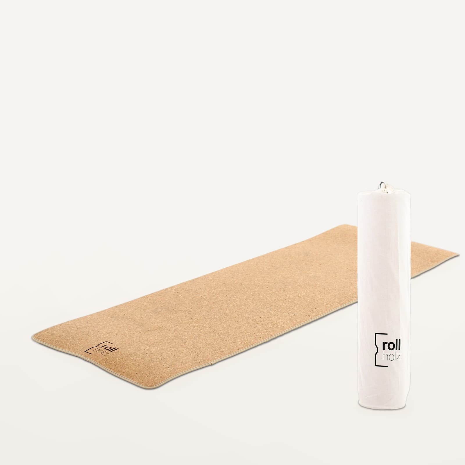 Freigestellte Produktansicht der rollholz Kork-Yogamatte flach ausgerollt neben der passenden weißen Leinentasche mit Logo-Branding.