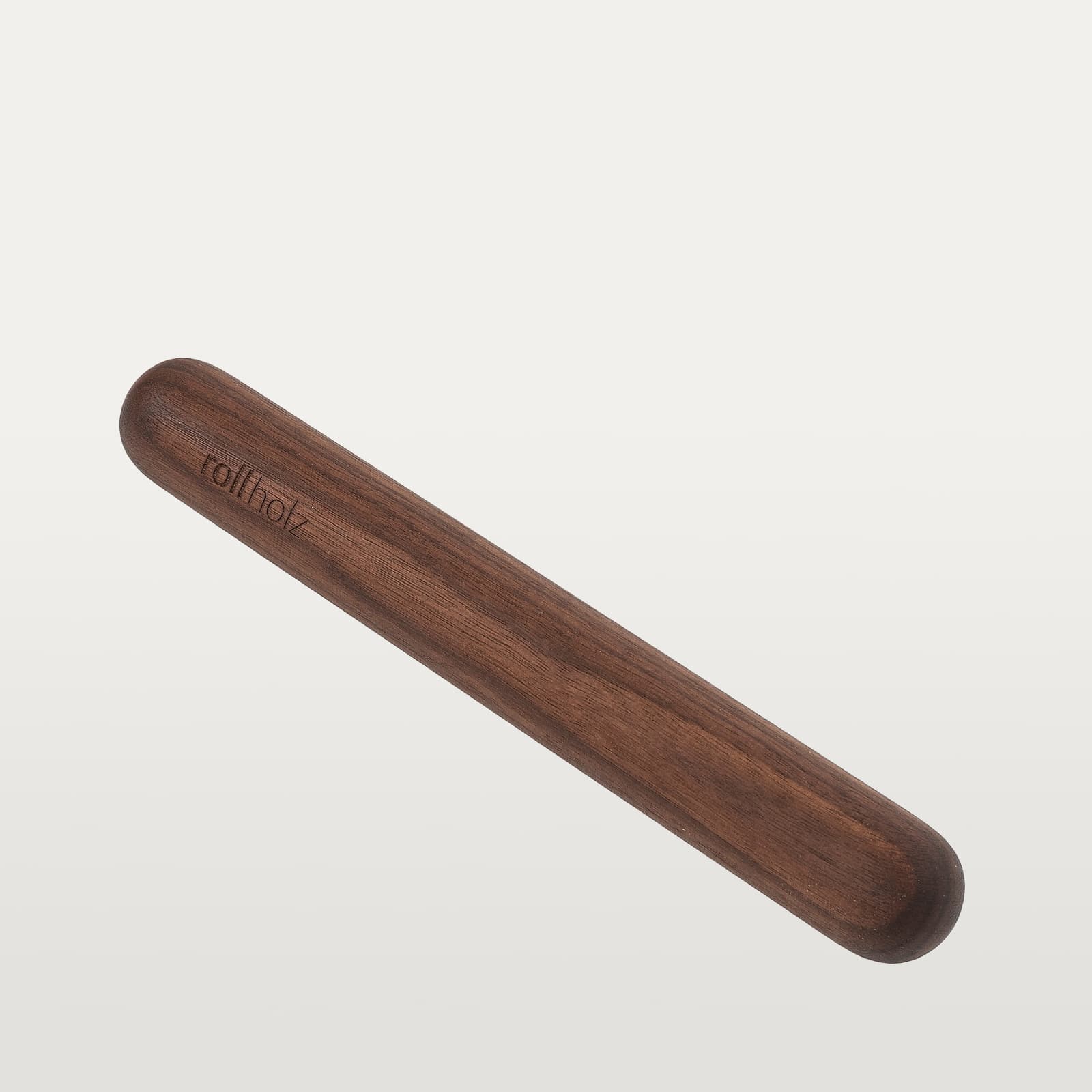#Holz_Walnuss Freigestellte Ansicht einer rollholz Minirolle aus edlem, dunklem Walnussholz mit präzise eingelasertem Markenlogo.