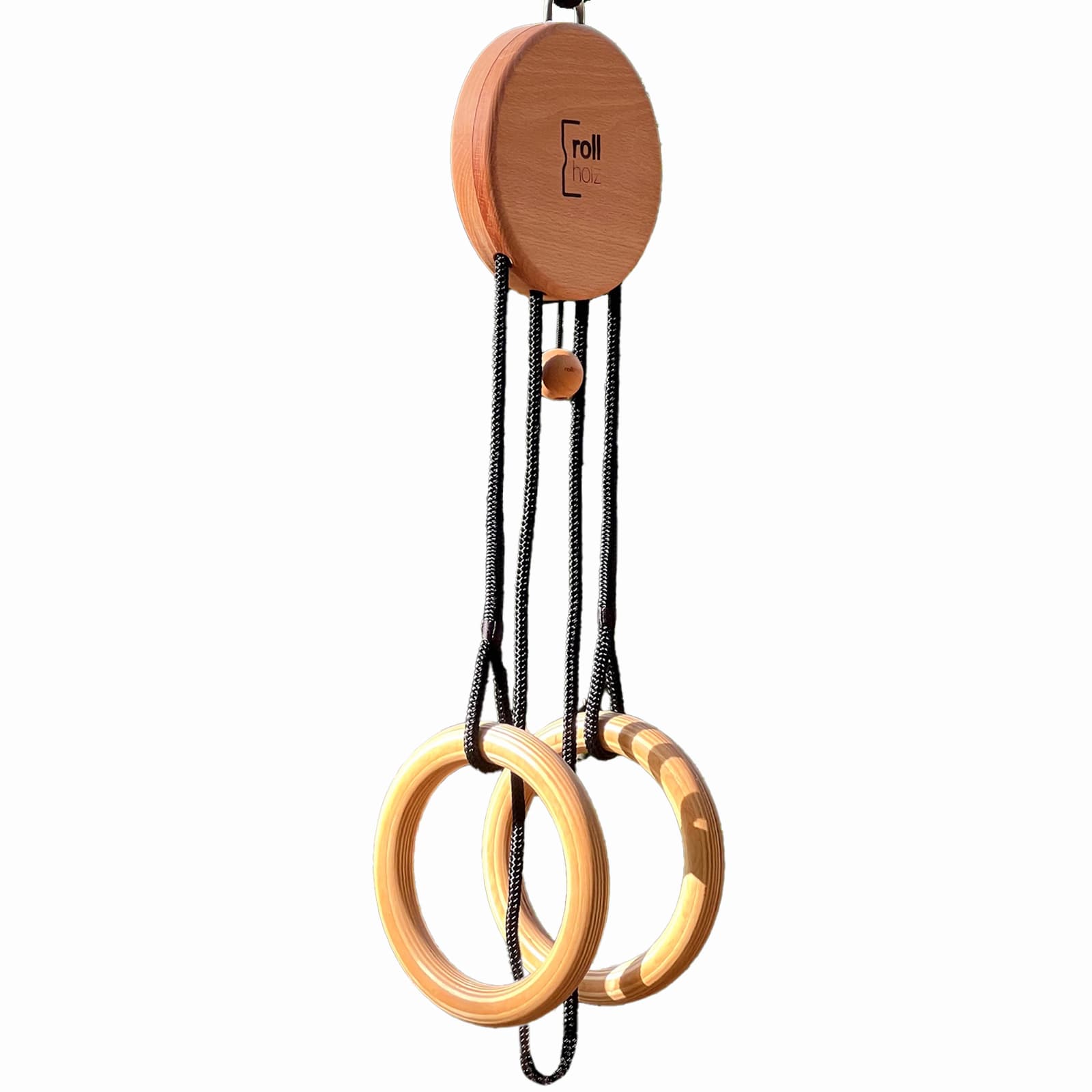 Der rollholz Schlingentrainer mit hölzerner Umlenkrolle, schwarzen Seilen und zwei hölzernen Turnringen, freigestellt auf weißem Hintergrund.