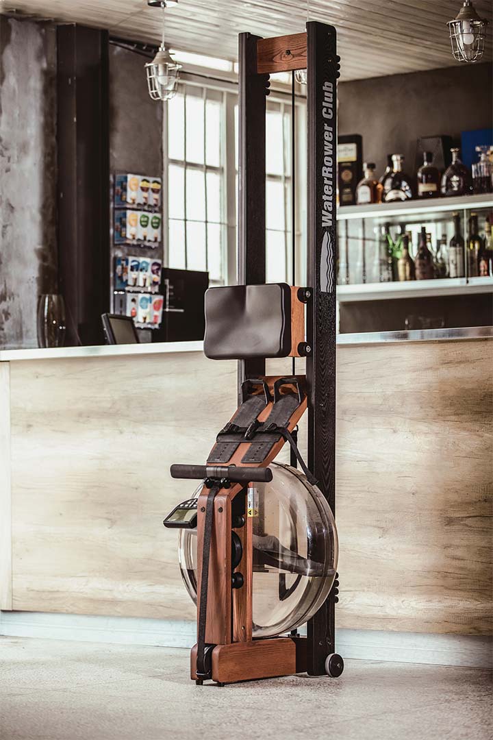 WaterRower Rudergerät aus Holz platzsparend aufrecht in einem modernen Wohnraum verstaut.